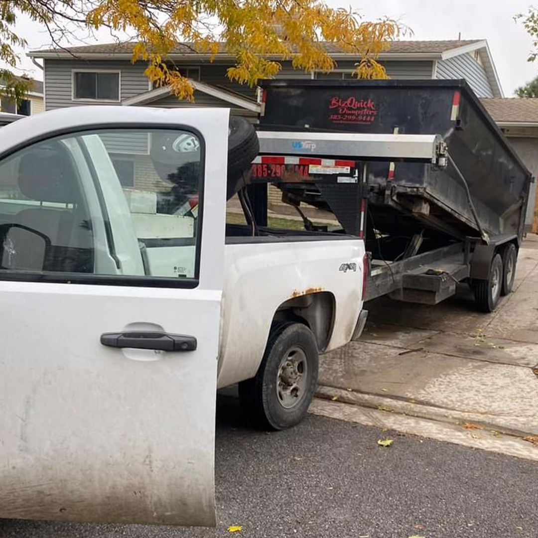 Gray's Handyman truck delivering a roll-off dumpster trailer to a West Jordan home