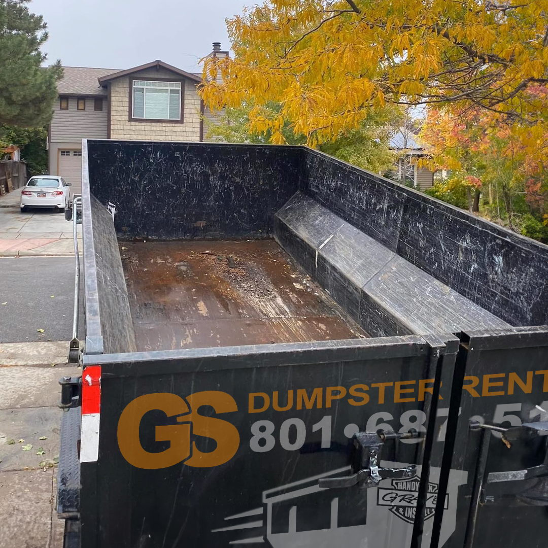 GS Dumpster Rentals roll-off dumpster parked on a residential driveway in Utah